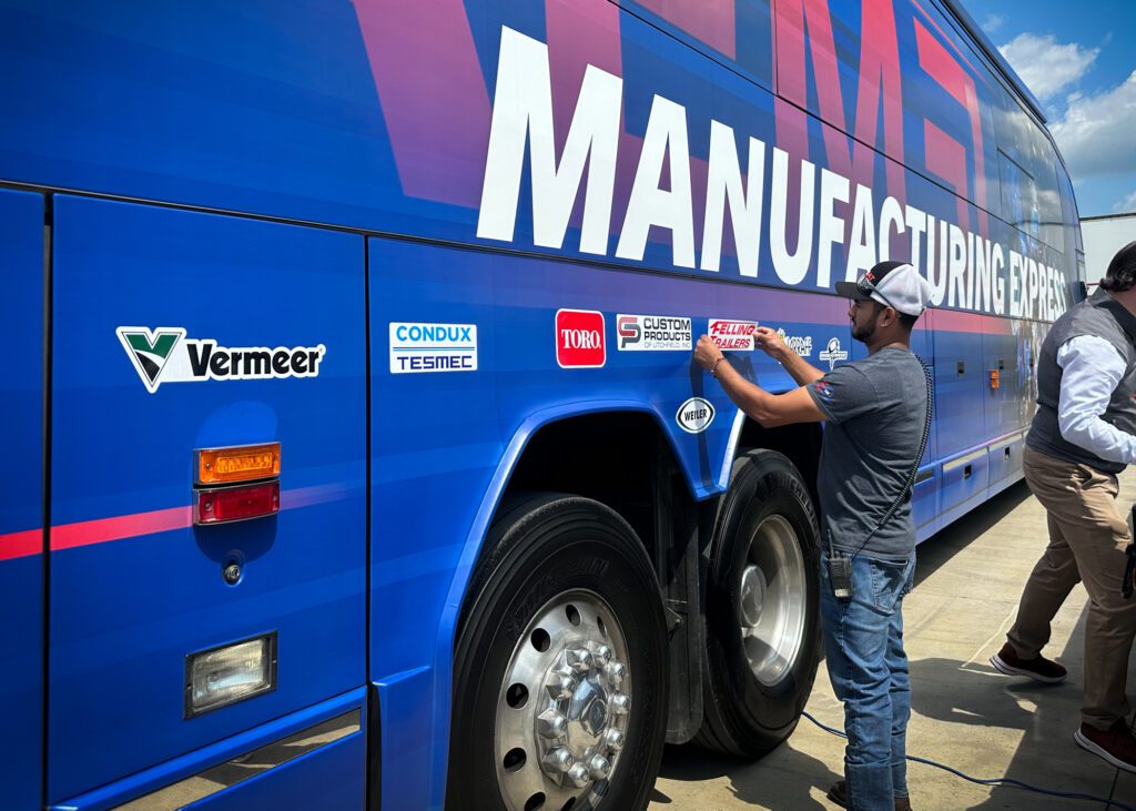 Felling Trailers Juan Juarez Placing Felling Trailers Decal on AEM Manufacturing Express